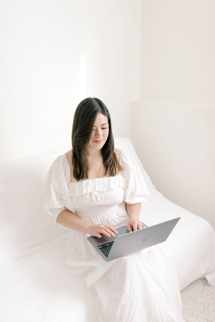 taylor white education on her laptop sitting on a couch